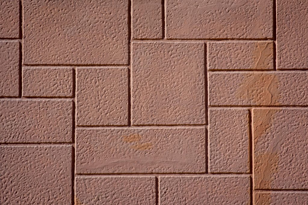 Close-up view of textured brown concrete paving stones arranged in an interlocking pattern.